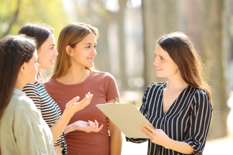 Woman with clipboard interviewing women